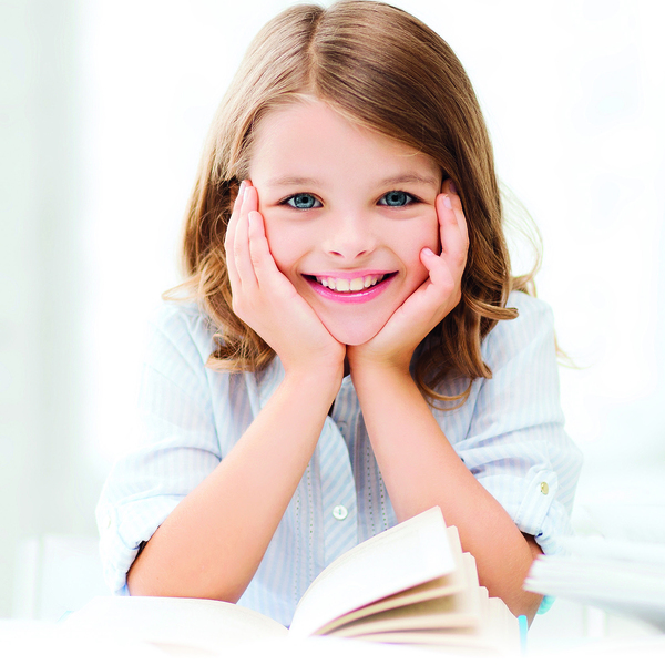 education and school concept - little student girl studying and reading book at school