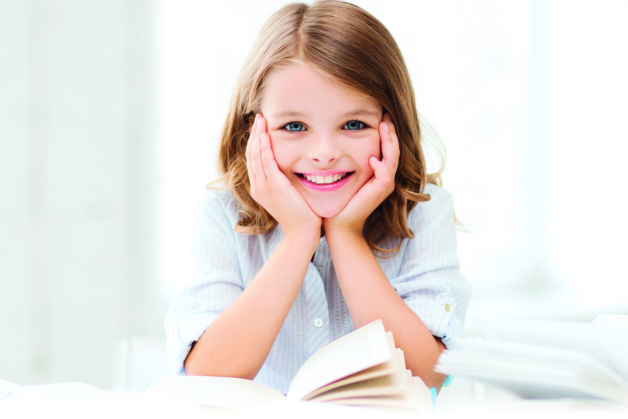 education and school concept - little student girl studying and reading book at school